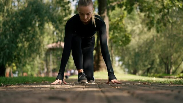 A professional girl athlete prepares for speed race during a morning workout in the park active lifestyle