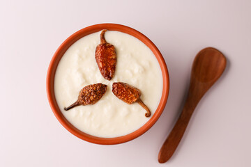 Bowl of homemade sour cream curd yogurt Dahi fresh herbs curry leaf Kerala India. Dairy product...