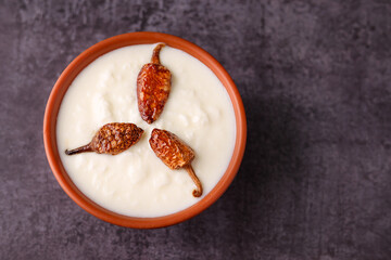 Bowl of homemade sour cream curd yogurt Dahi fresh herbs curry leaf Kerala India. Dairy product...