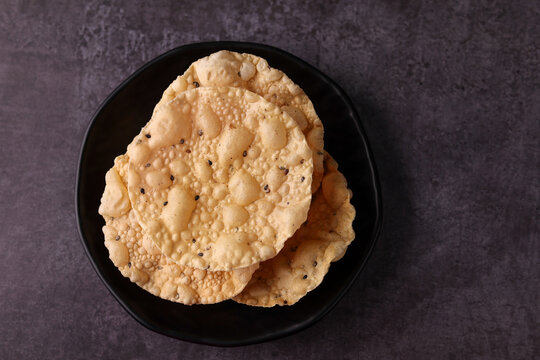 Papadam a traditional indian snack. papad or papadum in raw dried form with roasted cone roll and flat variation