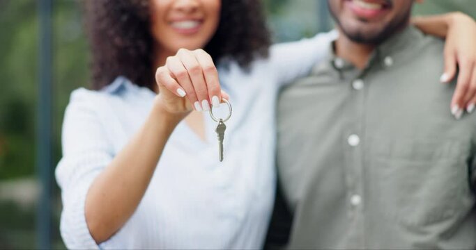 Hands, couple and keys outdoor of new home, real estate and building investment in neighborhood. Closeup, happy man and woman celebrate finance with key for moving to house, property or mortgage loan