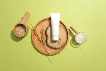 A cosmetic tube with rice bran extract stands out on a pastel background. Skin care with natural...