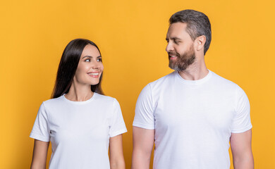 Fototapeta premium Boyfriend girlfriend. Couple of man and woman isolated on yellow. Family couple relationship. Millennial man and woman wearing white tshirt. Casual style of millennial couple. Married couple