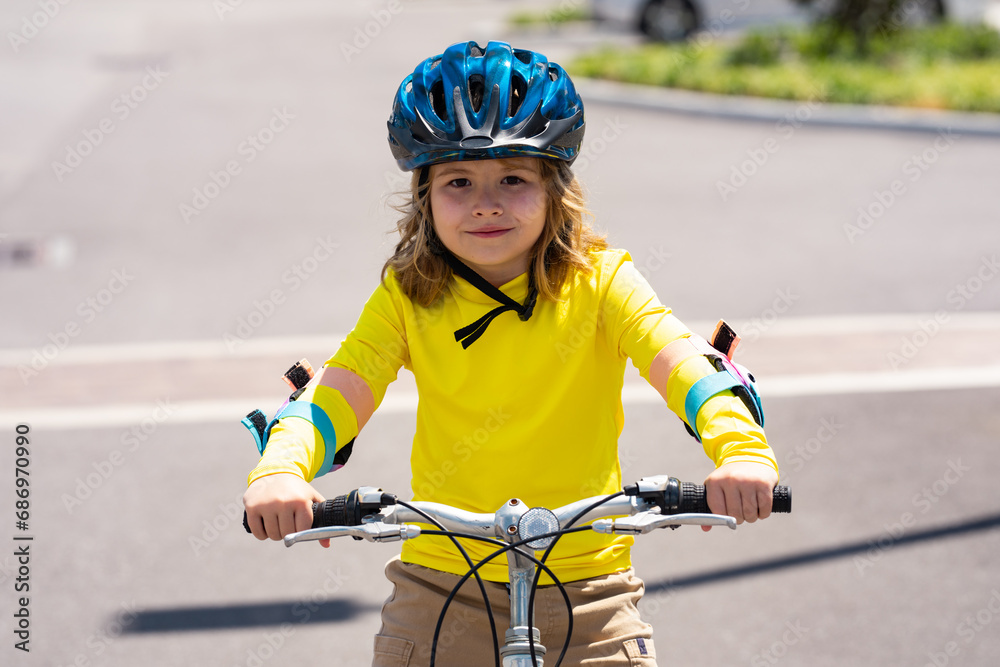 Wall mural Sporty kid riding bike on a park. Child in safety helmet riding bicycle. Kid learns to ride a bike. Kids on bicycle. Happy child in helmet cycling outdoor. Sports leisure with kids.