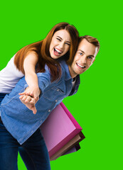 Happy excited young couple with megaphone. Man and woman shout saying advertising something in loudspeaker mega phone. Sales, rebates, discounts offers ad concept. Isolated green chroma key background