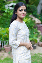 Happy Young Indian woman standing in public park enjoying. lifestyle concept