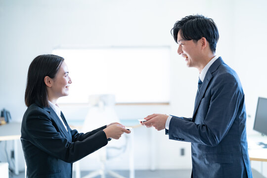 オフィスで名刺交換する若い男女ビジネスマン
