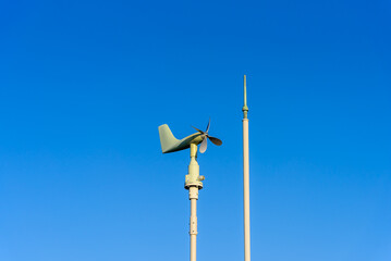 Wind direction plane on blue sky background, energy conservation concept.
