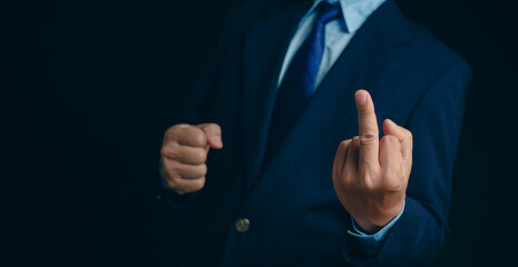 Angry, stress and portrait of businessman with a middle finger on a dark background in studio. Crazy, anger and a frustrated Japanese businessman showing an offensive, vulgar and rude hand gesture