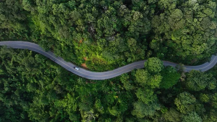 Foto op Canvas Aerial view of a road in the middle of the forest , road curve construction up to mountain © Hand Robot