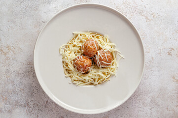 pasta in cream sauce with meatballs and grated parmesan