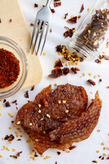 Dried meat, jerky on a white background with spices