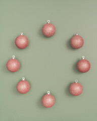 Pink Ornaments As A Wreath on a Green Background