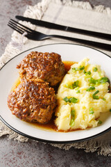 Hollandse Gehaktballen Dutch large Meat Balls served with mashed potatoes and gravy closeup on the plate on the table. Vertical