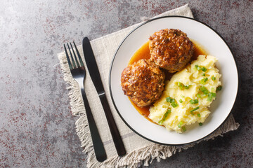 Dutch food a dish of meatballs gehaktballen served with mashed potatoes closeup on the plate on the table. Horizontal top view from above