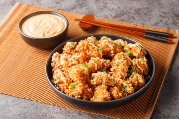 Bang Bang Chicken amazingly crisp chicken bites drizzled with sauce closeup on the plate on the table. Horizontal