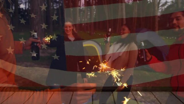 Animation of flag of america over diverse friends drinking beers campsite having fun with sparklers