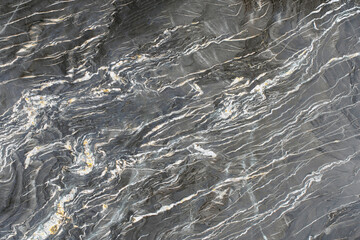Granite rock on the cut, gray color with light layers, high quality texture