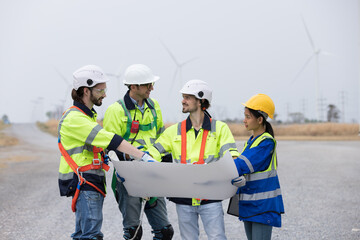 Group of male and female engineer working at wind turbines farm, planing maintenance of wind...