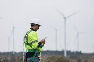 Male engineer working with plan maintenance of wind turbines at windmill field farm. Male engineer...