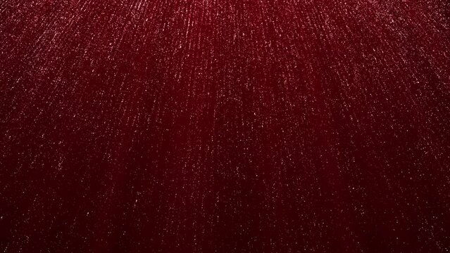 Dark red abstract background with moving shiny particles , moving up and down . Animated holiday background.