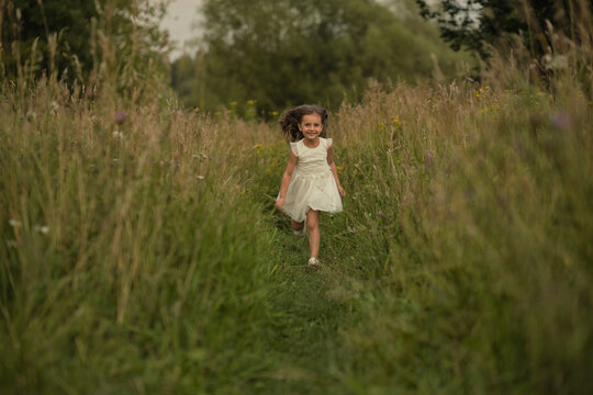 In mid-stride, the girl exudes excitement, against the backdrop of nature s embrace. The scene captures the essence of current trends towards experiential learning and play.