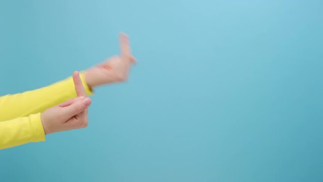 Close up of female hand showing middle finger, impolite rude gesture of disrespect, hate and aggression in conflict, posing isolated over plain blue color background wall in studio with copy space
