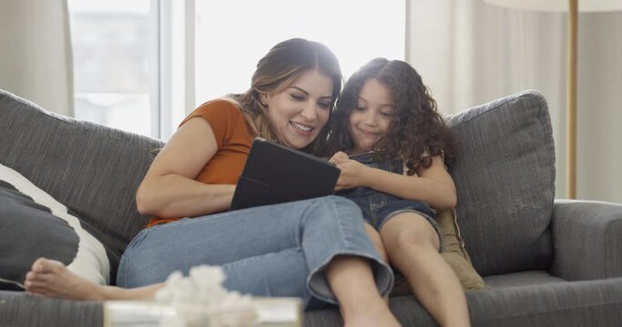 Mother, child and tablet on couch, social media and streaming series and movie. Mom, daughter and digital technology on sofa, mobile app and funny joke or online humor, conversation and chat or game