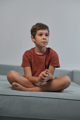 Obraz premium With a mischievous smile, he sits relaxed, highlighting the importance of downtime in children's increasingly busy lives.