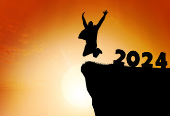 Silhouette of a person leaping from 2024 on the top of the mountain background.