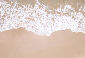 Drone view ocean foam. Transparent clear wave coming on sandy beach aerial shot.