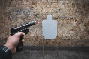 Christmas and shooting at a idpa target with bullet holes at a shooting range. A pistol with a...