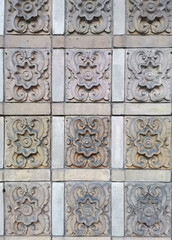 Wall stucco floral pattern detail on a building facade close-up