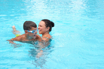 Mother and son's pool time; cherished vacation joy. Aligns with the movement towards quality family time in tourism.
