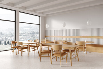 Stylish cafe interior with woodden table and seats, eating corner near window