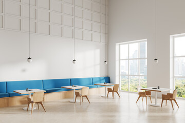 White cafe interior with table and chairs in row, couch and panoramic window
