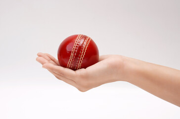 Shiny Red Test Match Leather Stitch Cricket Ball In Women Hand Closeup Picture White Background