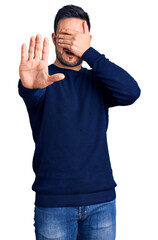 Fototapeta premium Young handsome man wearing casual clothes covering eyes with hands and doing stop gesture with sad and fear expression. embarrassed and negative concept.