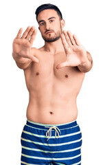 Fototapeta premium Young handsome man wearing swimwear doing frame using hands palms and fingers, camera perspective