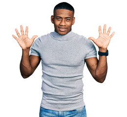 Young black man wearing casual t shirt showing and pointing up with fingers number ten while smiling confident and happy.
