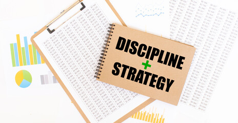Text discipline and strategy on brown paper notepad on the table with diagram. Business concept