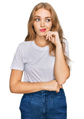 Young caucasian girl wearing casual white t shirt serious face thinking about question with hand on chin, thoughtful about confusing idea