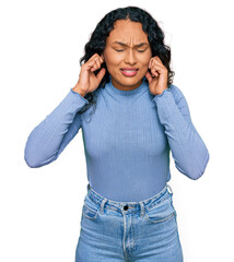 Young hispanic woman with curly hair wearing casual clothes covering ears with fingers with annoyed expression for the noise of loud music. deaf concept.