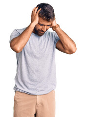 Fototapeta premium Young hispanic man wearing casual clothes suffering from headache desperate and stressed because pain and migraine. hands on head.