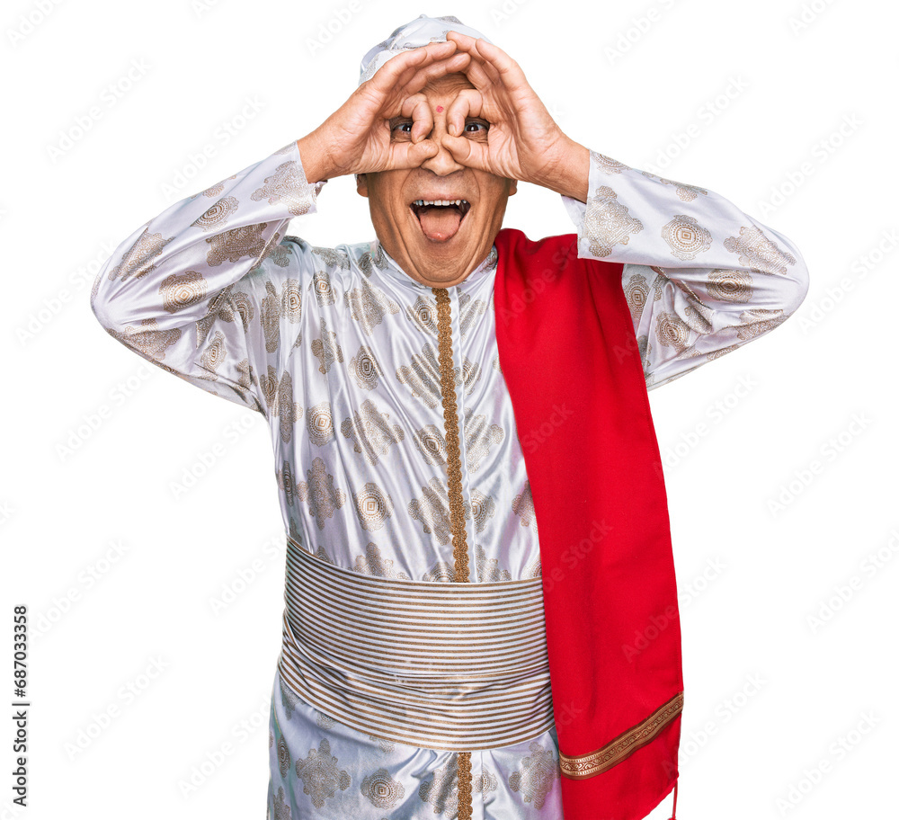 Canvas Prints Senior hispanic man wearing tradition sherwani saree clothes doing ok gesture like binoculars sticking tongue out, eyes looking through fingers. crazy expression.