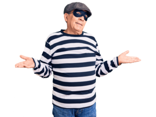 Senior handsome man wearing burglar mask and t-shirt clueless and confused expression with arms and hands raised. doubt concept.