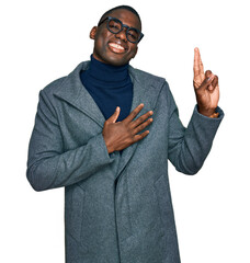 Young african american man wearing business clothes and glasses smiling swearing with hand on chest...