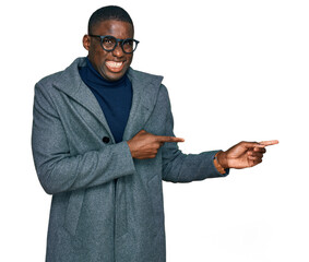 Young african american man wearing business clothes and glasses pointing aside worried and nervous with both hands, concerned and surprised expression
