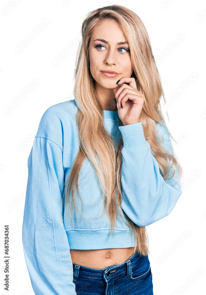 Wall mural beautiful young blonde woman wearing casual sweatshirt thinking concentrated about doubt with finger