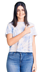 Fototapeta premium Young beautiful girl wearing casual t shirt cheerful with a smile on face pointing with hand and finger up to the side with happy and natural expression
